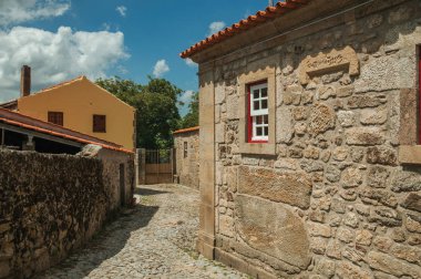 Bir sokakta taş duvar ve küçük pencere ile eski ev