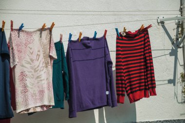 Binanın önünde kurumaya asılı renkli giysiler