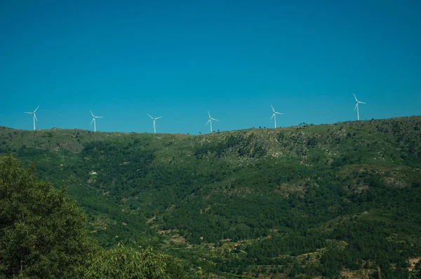 Wind turbines for electric power generation over hill — ストック写真