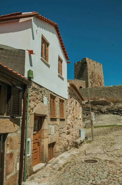 Сельский дом перед каменной стеной и квадратной башней — стоковое фото