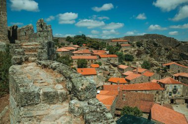 Eski evlerin çatılarının yanındaki taş duvar üzerinde patika