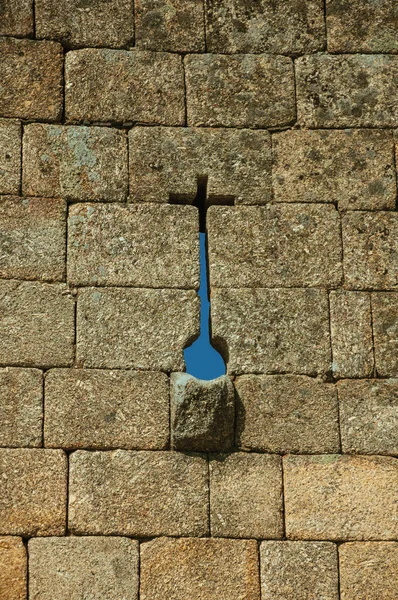Узкая щель в крестообразной форме и канава на каменной стене — стоковое фото