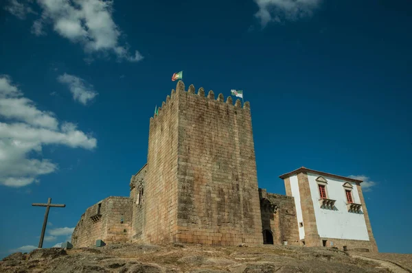 Castillo y torre cuadrada sobre colina rocosa con cruz — Foto de Stock