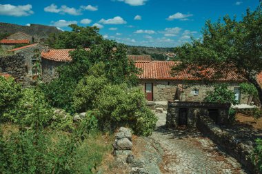 Bahçe ve taş evlerden geçen patika