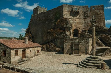 Castle and old houses encircling square with pillory clipart