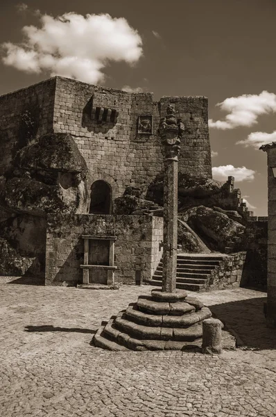 Castle facade over rocky hill on square with pillory — стокове фото