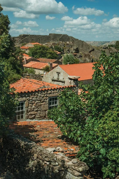 Telhados de pedra casas antigas com árvores frondosas — Fotografia de Stock