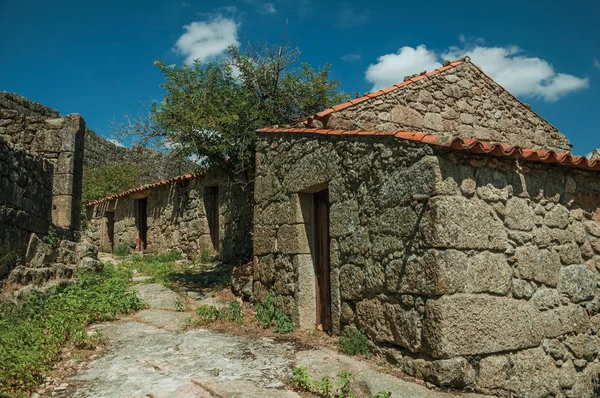 Yamaç ve duvar üzerinde bir sokakta taştan yapılmış ev — Stok fotoğraf