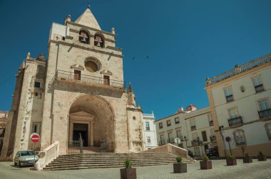 Terk edilmiş bir meydanda katedral cephesi ve eski binalar