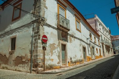 Soyulmuş alçılı ve giriş tabelası olmayan beyaz evler.