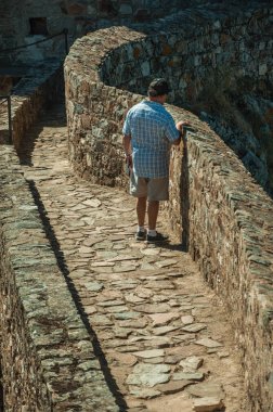 Marvao Kalesi'ndeki duvarda patikaboyunca duran adam