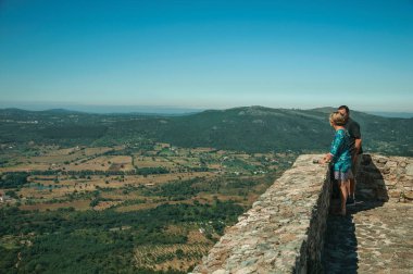 Marvao Kalesi'nden engebeli manzaraya bakan turistler
