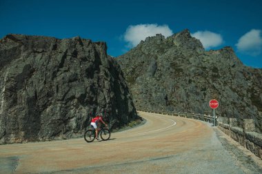 Bisikletçi ile kayalık manzara dan geçen yol