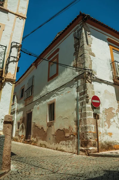 Casas blancas con yeso pelado y NO ENTRADA señal de tráfico — Foto de Stock