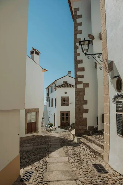 Oude huizen met witgekalkte muur in geplaveide steegje op helling — Stockfoto