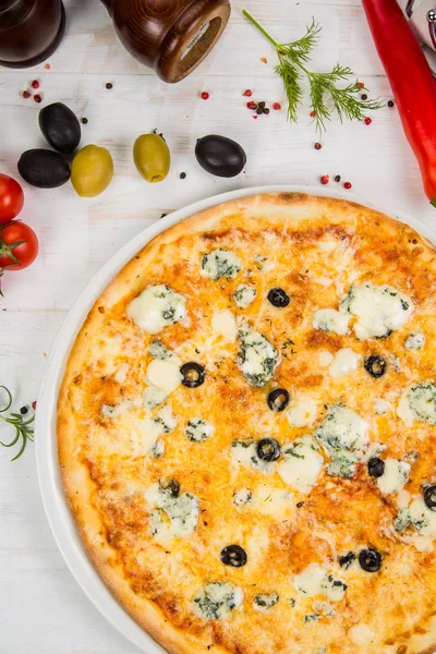 4 pizza al formaggio su fondo bianco in legno. Sfondo decorato con verdure — Foto Stock