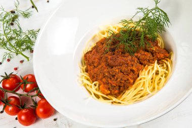 İtalyan makarna bolognese. Kiraz domates ve biber ile süsleyin. Beyaz arka plan üzerinde