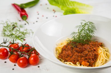 İtalyan makarna bolognese. Kiraz domates ve biber ile süsleyin. Beyaz arka plan üzerinde