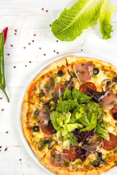 Mozzarella peynirli biberli pizza, salam, domates, biber, baharat ve taze fesleğen. İtalyan pizzası