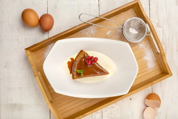 ahşap bir tepsi üzerinde, hafif bir arka planda beyaz bir plaka krem üzerinde tarih Cupcake