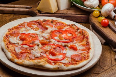 ahşap bir tahta üzerinde salam pizza, ahşap arka plan sebze ve çatal ile dekore
