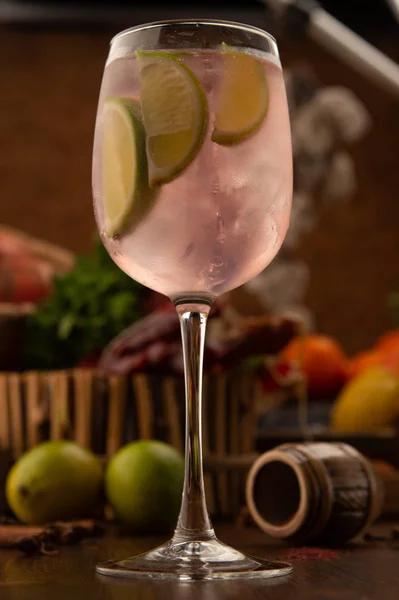 Cocktail citron vert dékoré dans un verre de vigne sur un fond en bois. Fond décoré avec des fruits et des herbes . — Photo