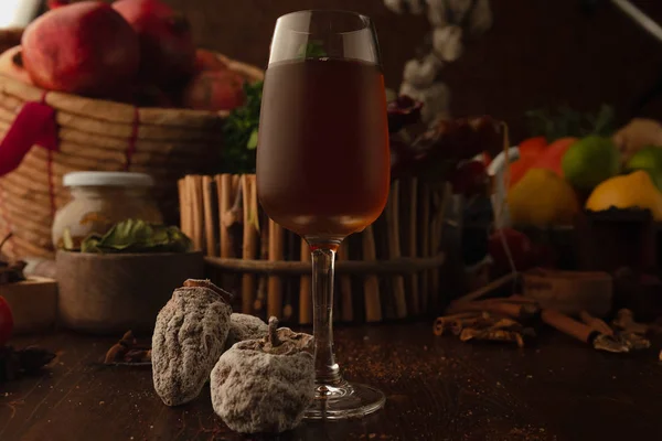 Cocktail in een glas op een houten achtergrond. Achtergrond versierd met fruit en kruiden. — Stockfoto