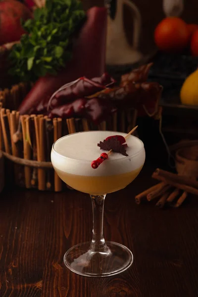 Schönen Cocktail im Chalet auf einem Holzgrund. Hintergrund mit Früchten und Kräutern dekoriert. — Stockfoto