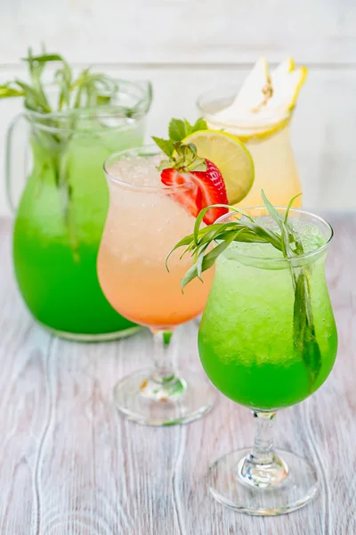 A variety of soft drinks. Assortment of soft drinks. Tarragon lemonade, Strawberry lemonade, Pear lemonade. Lemonade on a light background. — Stock Photo, Image