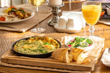 Maydanoz ve dereotlu tavada omlet. Taze ekmek ve taze sebzelerle servis yapın..