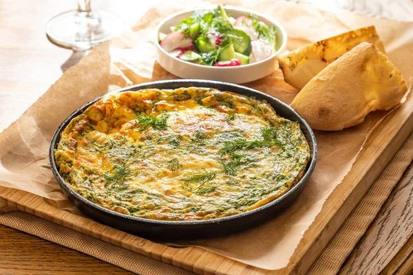 Maydanoz ve dereotlu tavada omlet. Taze ekmek ve taze sebzelerle servis yapın..