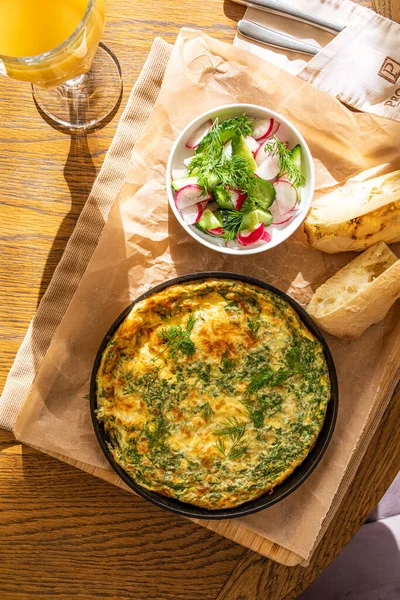 Maydanoz ve dereotlu tavada omlet. Taze ekmek ve taze sebzelerle servis yapın..