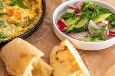 Maydanoz ve dereotlu tavada omlet. Taze ekmek ve taze sebzelerle servis yapın..