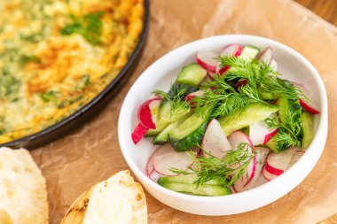 Maydanoz ve dereotlu tavada omlet. Taze ekmek ve taze sebzelerle servis yapın..