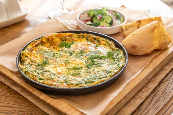 Maydanoz ve dereotlu tavada omlet. Taze ekmek ve taze sebzelerle servis yapın..