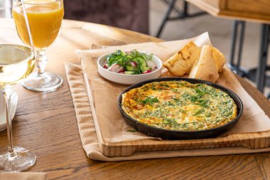 Maydanoz ve dereotlu tavada omlet. Taze ekmek ve taze sebzelerle servis yapın..