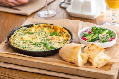 Maydanoz ve dereotlu tavada omlet. Taze ekmek ve taze sebzelerle servis yapın..