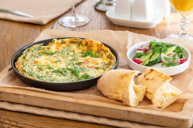 Maydanoz ve dereotlu tavada omlet. Taze ekmek ve taze sebzelerle servis yapın..