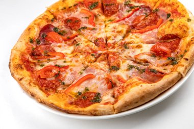 Beyaz tabakta jambonlu, sosisli ve domatesli pizza