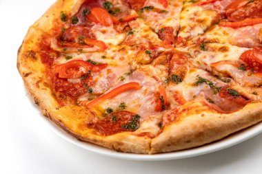 Beyaz tabakta jambonlu, sosisli ve domatesli pizza