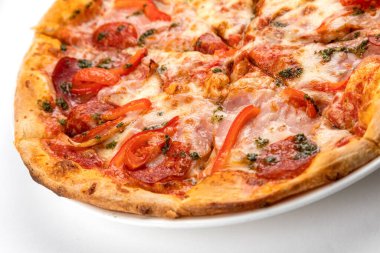 Beyaz tabakta jambonlu, sosisli ve domatesli pizza