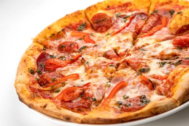 Beyaz tabakta jambonlu, sosisli ve domatesli pizza