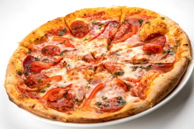 Beyaz tabakta jambonlu, sosisli ve domatesli pizza