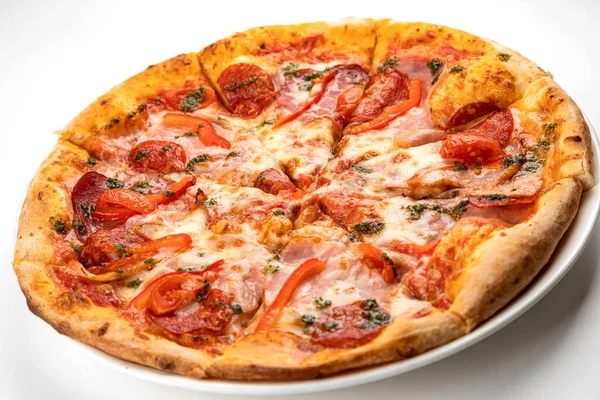 Beyaz tabakta jambonlu, sosisli ve domatesli pizza