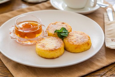 Reçelli cheesecake ile kahvaltı. Arka planda bir fincan çay..