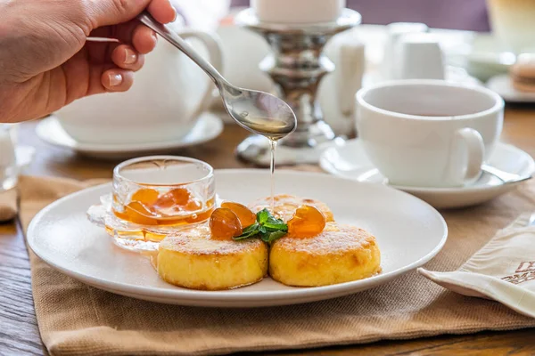 Peynirli kekler reçelle doldurulur. Reçelli cheesecake ile kahvaltı. Arka planda bir fincan çay..