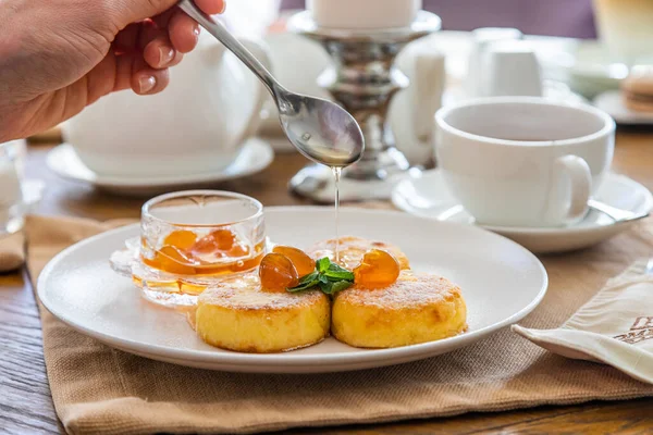 Peynirli kekler reçelle doldurulur. Reçelli cheesecake ile kahvaltı. Arka planda bir fincan çay..