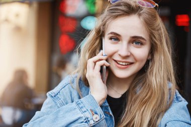 Bekle sn cevap çağrı gerekir. Portre sevimli mavi gözlü kot ceketli meşgul iyi görünümlü kadın Freelancer smartphone kulak ve ofise yürürken kameraya bakan yakın tutarak