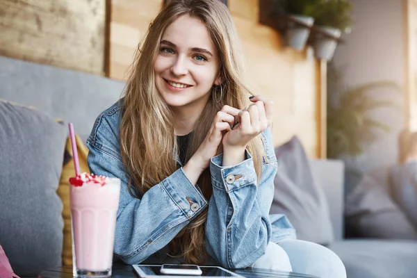 Vodorovný záběr přátelské evropských přítelkyně v elegantní džínové sako, posezení v kavárně, opíraje se o konferenční stolek zároveň právě zaujalo zajímavé konverzace, pití koktejlů a mluvící — Stock fotografie