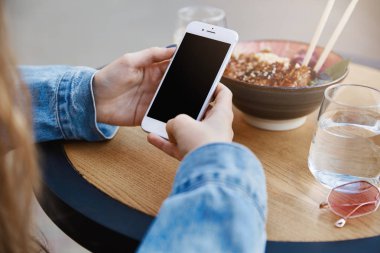 Ramen yeme sokak gıda alanında, yemek çubukları ile baharatlı gıda sevme beyaz smartphone tutarak ve fotoğrafta o emretti gıda Asya Restoran, şık genç erkek kadeh kırpılmış